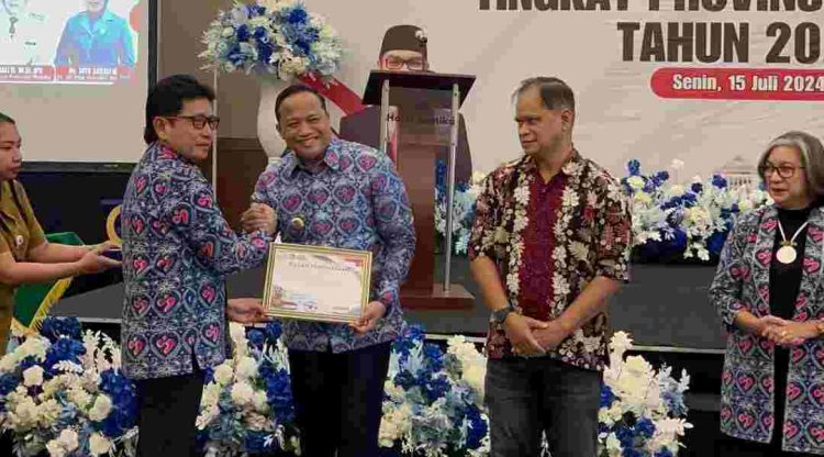 Pj. Gubernur Maluku Sadali Ie menyerahkan penghargaan kepada Pj. Bupati Malra Jasmono dalam acara Peringatan Hari Keluarga Nasional ke-31 Tingkat Provinsi Maluku di Ambon, Senin (15/7/2024). Foto: Dokpri